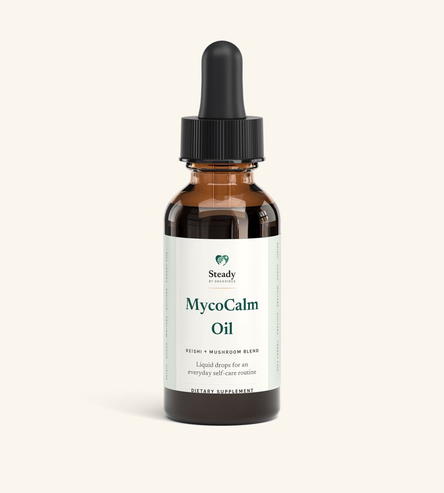 MycoCalm Oil: an amber glass dropper bottle with a black dropper cap and a cream Steady label, on a warm cream ground.